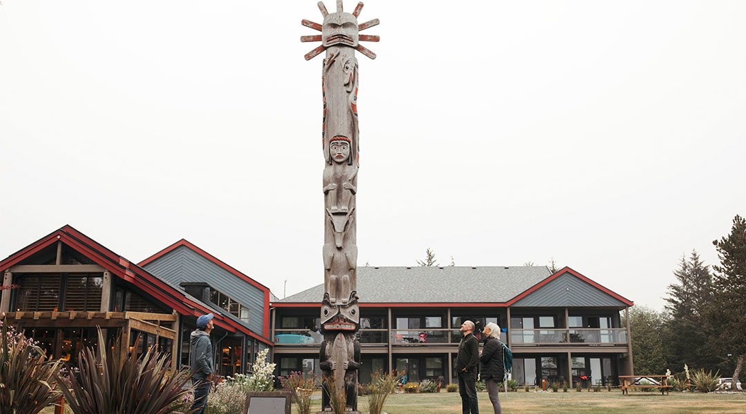 Exterior photo of hotel with people looking at totem pole Exterior photo of hotel with people looking at totem pole