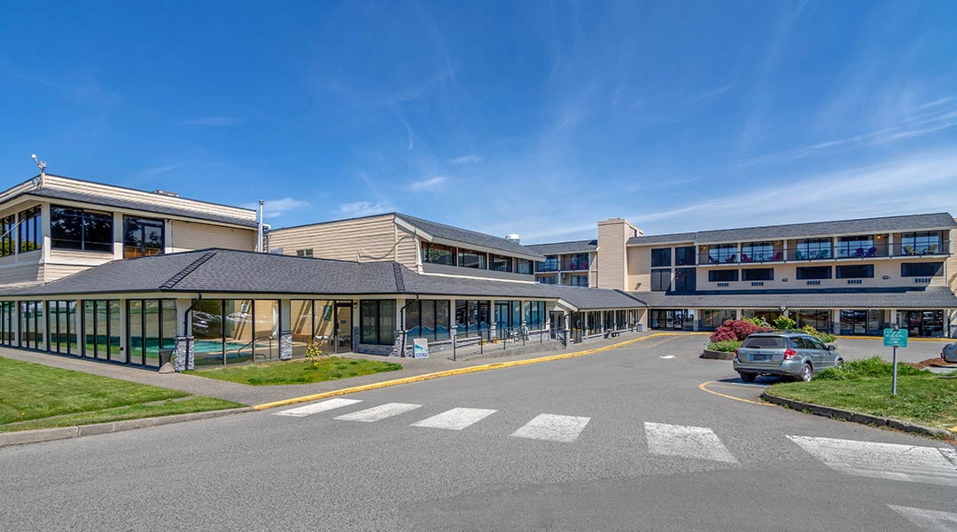 The exterior building and parking lot of the Bayside Oceanfront Resort in Parksville