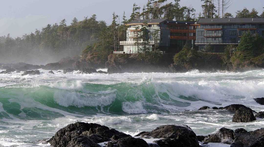 The exterior of the Black Rock Oceanfront Resort by the ocean with large waves coming in in Ucluelet The exterior of the Black Rock Oceanfront Resort by the ocean with large waves coming in in Ucluelet