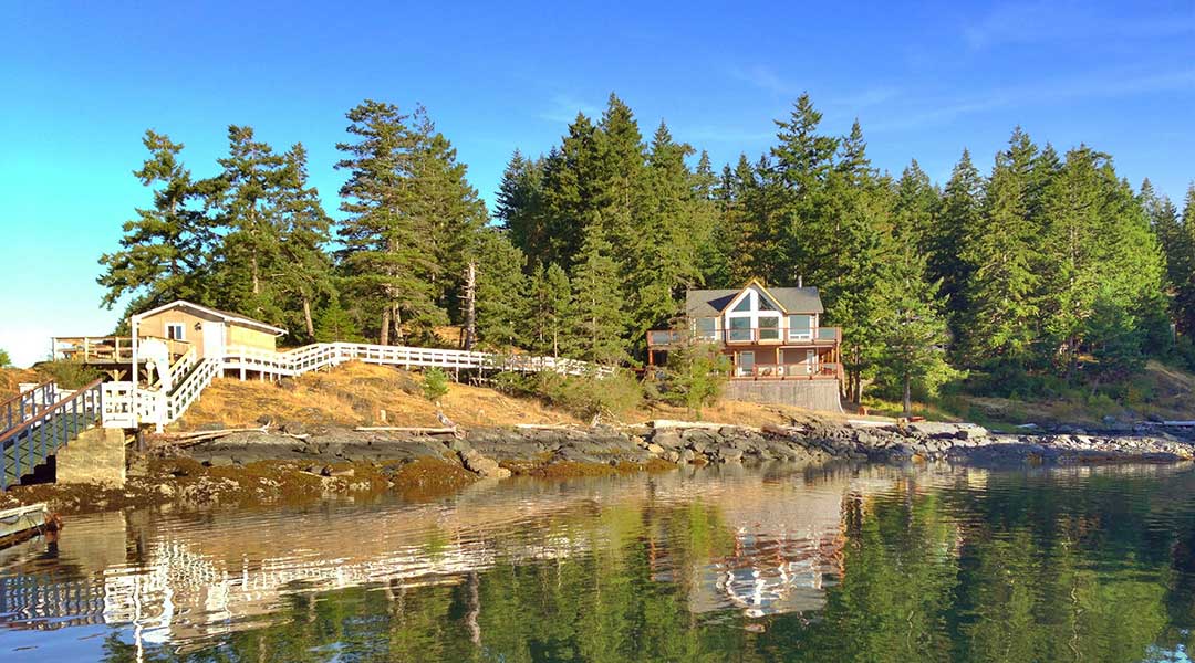 The exterior building of the Gowlland Harbour Resort by the ocean on Quadra Island The exterior building of the Gowlland Harbour Resort by the ocean on Quadra Island