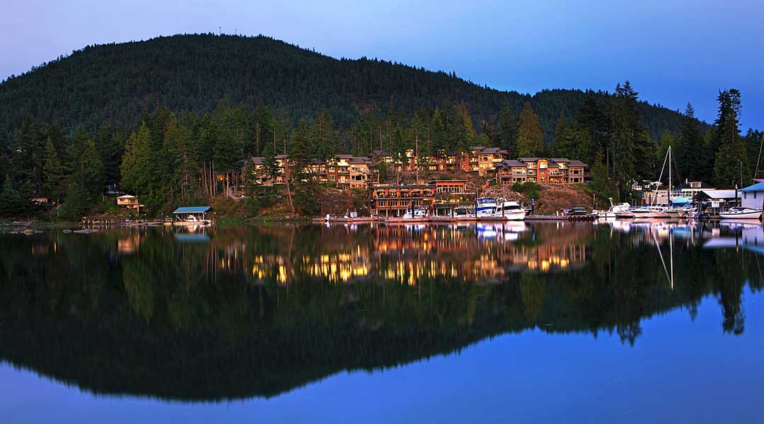 Exterior of the Painted Boat Resort Spa and Marina with the mountains and resort reflection off the water in Madeira Park Exterior of the Painted Boat Resort Spa and Marina with the mountains and resort reflection off the water in Madeira Park