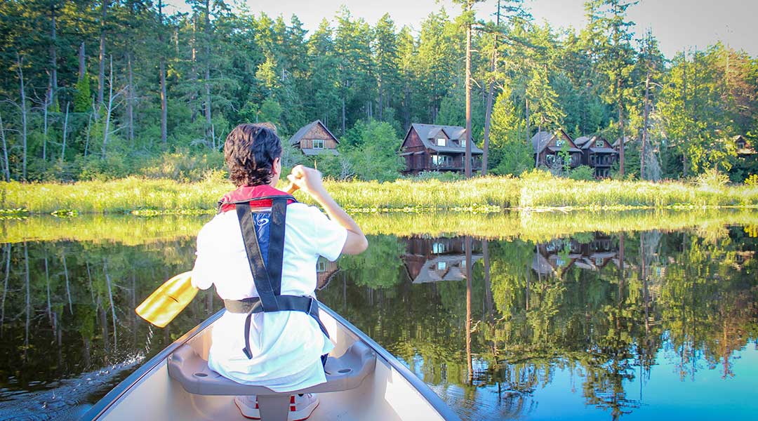 Person canoeing on Bullocks Lake near the Cottages on Salt Spring Island Person canoeing on Bullocks Lake near the Cottages on Salt Spring Island