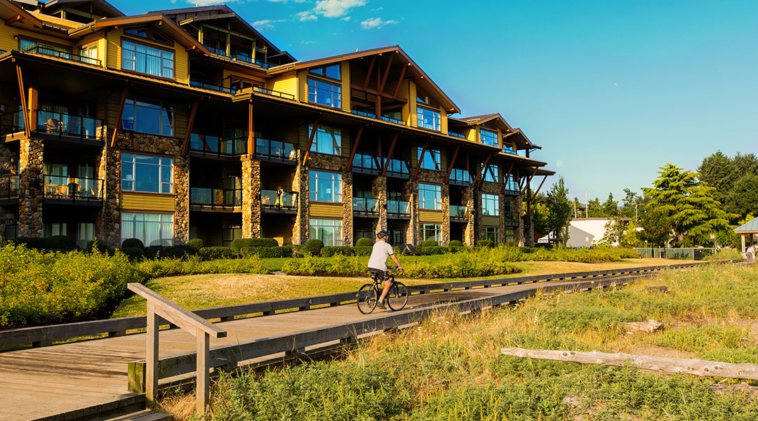 Person on bike cycling on a wooden boardwalk at The Beach Club Resort in Parksville Person on bike cycling on a wooden boardwalk at The Beach Club Resort in Parksville