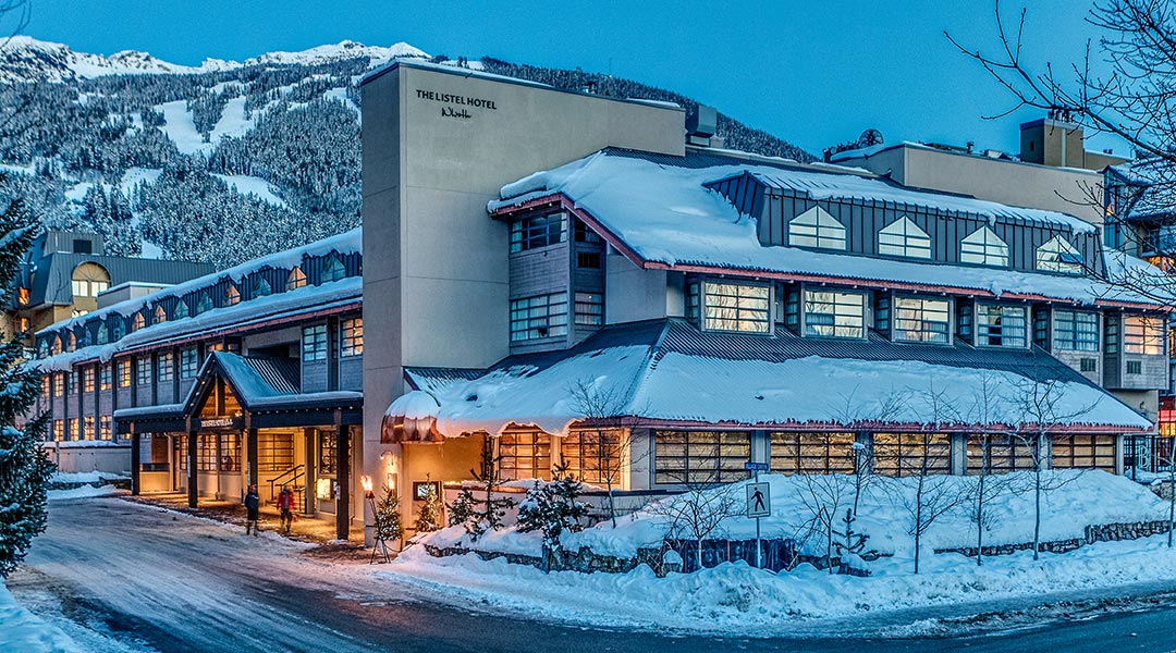The exterior building and entrance to The Listel Hotel Whistler covered in snow during winter The exterior building and entrance to The Listel Hotel Whistler covered in snow during winter