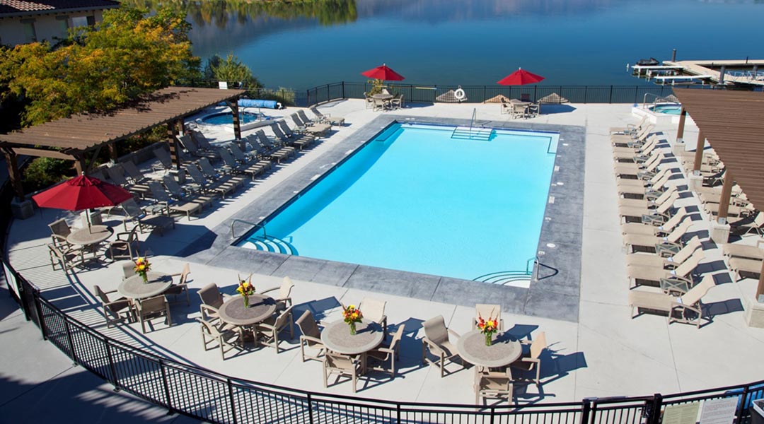 Aerial view of pool and lounge chairs at Walnut Beach Resort with lake beside in Osoyoos Okanagan Aerial view of pool and lounge chairs at Walnut Beach Resort with lake beside in Osoyoos Okanagan