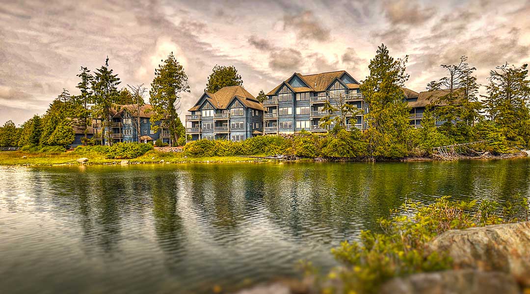 Exterior of Waters Edge Shoreside Suites with ocean in front and clouds in the sky in Ucluelet Exterior of Waters Edge Shoreside Suites with ocean in front and clouds in the sky in Ucluelet