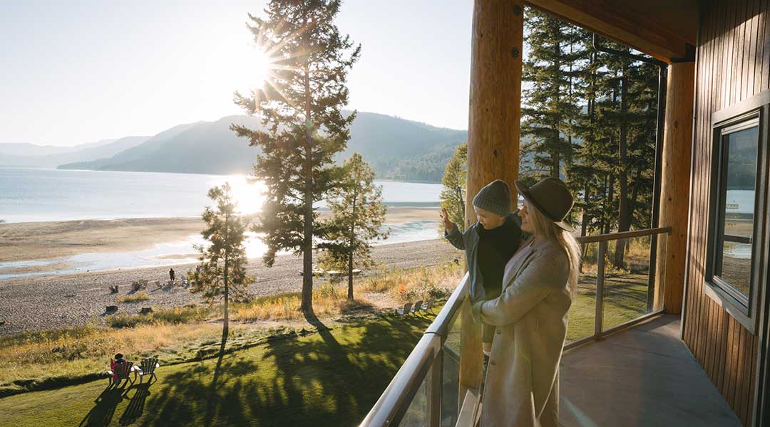 Family standing on balcony overlooking the beach and lake at Quaaout Lodge and Spa in Chase BC Family standing on balcony overlooking the beach and lake at Quaaout Lodge and Spa in Chase BC