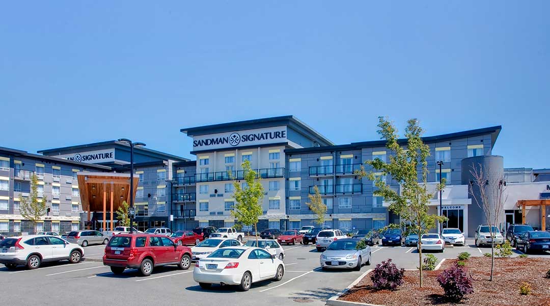 Exterior of Sandman Signature Langley Hotel with parking lot in front Exterior of Sandman Signature Langley Hotel with parking lot in front