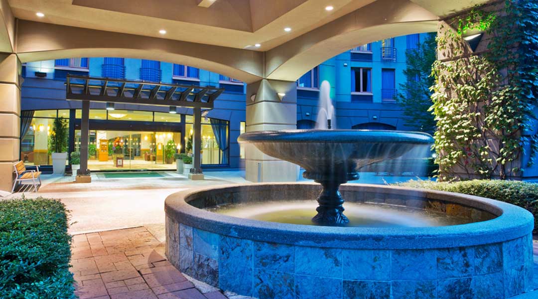 The exterior entrance and fountain of the Holiday Inn and Suites North Vancouver at night The exterior entrance and fountain of the Holiday Inn and Suites North Vancouver at night