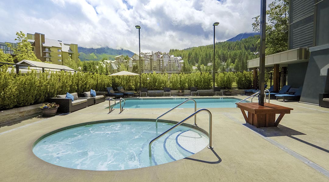 The exterior hot tub pool at the Aava Whistler Hotel with mountain views in the Coast Mountains