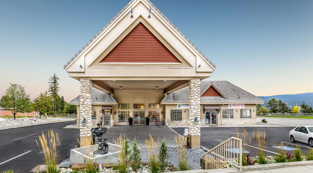 The exterior building and parking lot of the Prestige Radium Hot Springs Resort during the daytime The exterior building and parking lot of the Prestige Radium Hot Springs Resort during the daytime