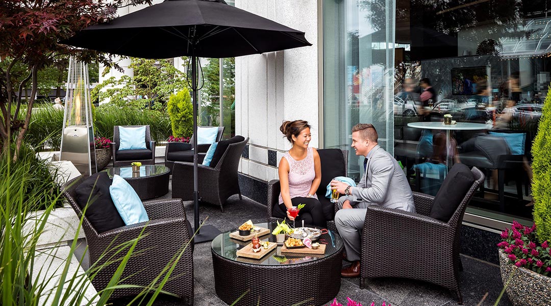 A couple enjoying a meal in the patio of ARC Restaurant in the Fairmont Waterfront in Downtown Vancouver