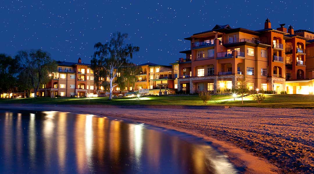 Beach in the evening with reflection of lights from resort on the lake at Watermark Beach Resort in Osoyoos Okanagan Beach in the evening with reflection of lights from resort on the lake at Watermark Beach Resort in Osoyoos Okanagan