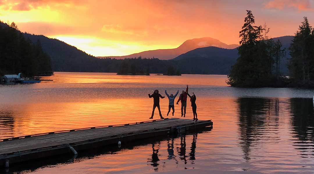 People standing on dock at sunset with purple skies at Ruby Lake Resort in Madeira Park on the Sunshine Coast People standing on dock at sunset with purple skies at Ruby Lake Resort in Madeira Park on the Sunshine Coast