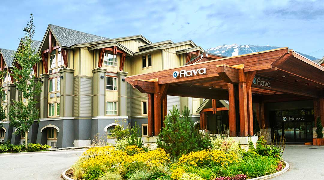 The exterior entrance and parking lot of the Aava Whistler Hotel in the Coast Mountains