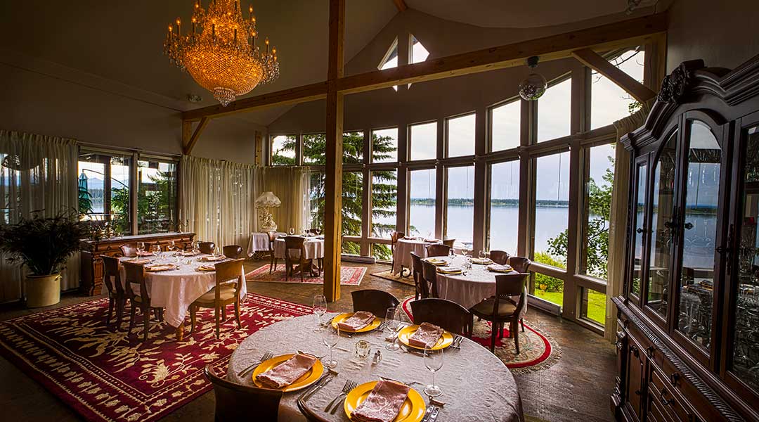 The dining room with many tables next to an ocean view at the Eagles Nest Resort in Anahim Lake Northern BC The dining room with many tables next to an ocean view at the Eagles Nest Resort in Anahim Lake Northern BC