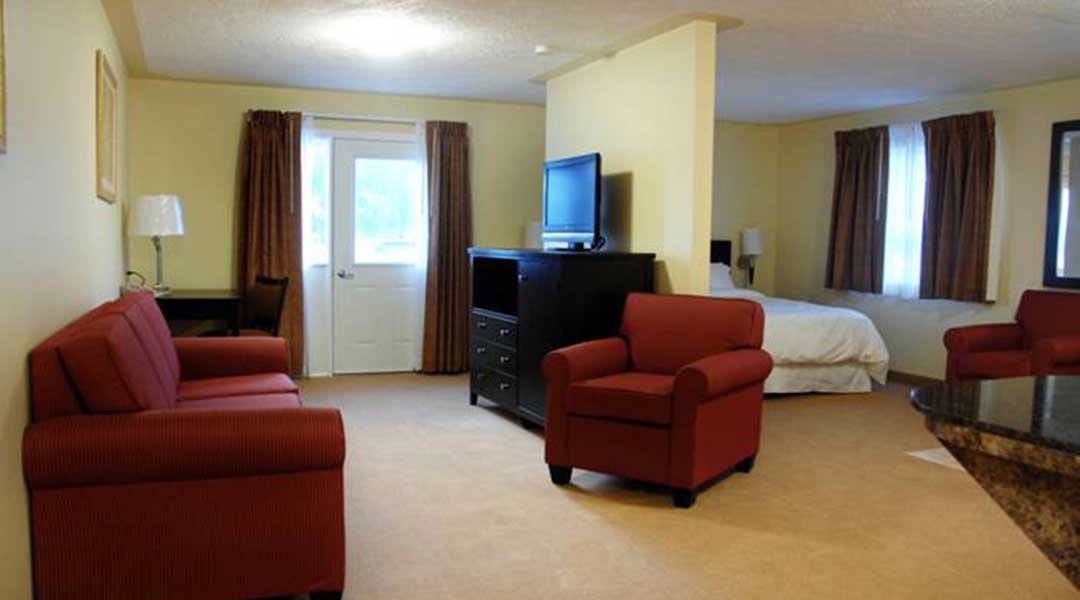 Sitting area with television and wall separating bed in the VIP suite at Sunshine Inn in Smithers BC Sitting area with television and wall separating bed in the VIP suite at Sunshine Inn in Smithers BC
