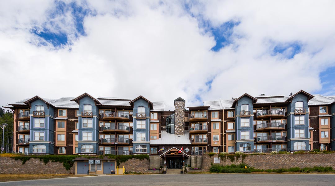 Exterior of Mount Washington Alpine Resort with blue skies and fluffy clouds on Vancouver Island Exterior of Mount Washington Alpine Resort with blue skies and fluffy clouds on Vancouver Island