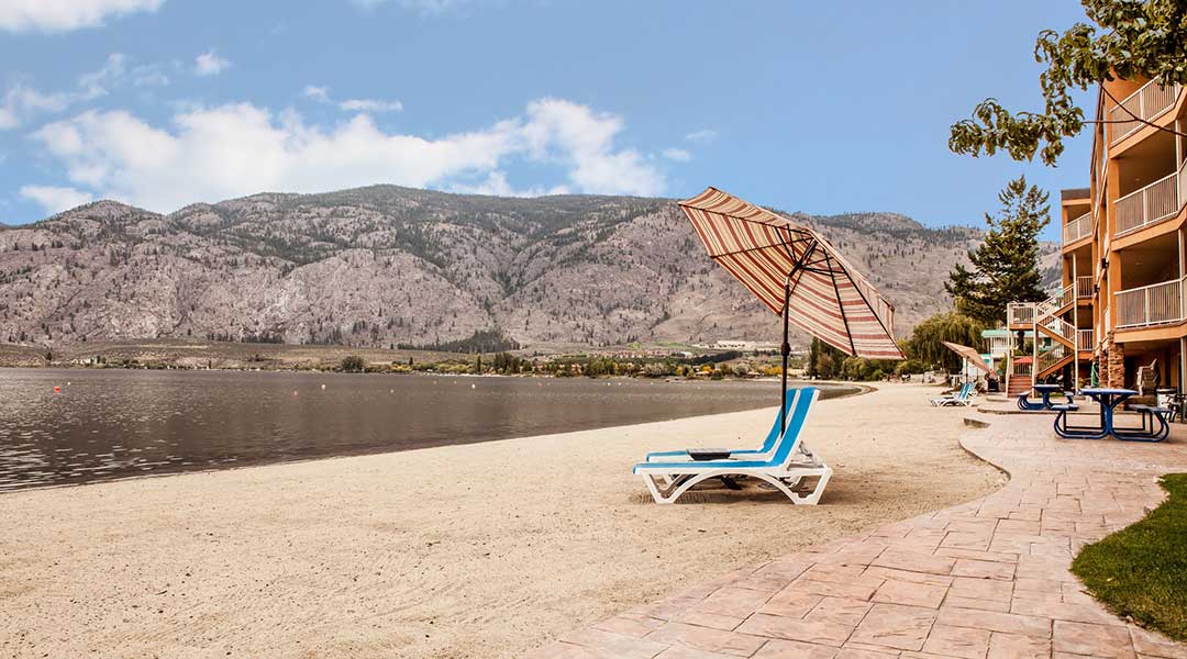 Beach chair in front of a lake outside the Coast Osoyoos Beach Hotel in Thompson Okanagan Beach chair in front of a lake outside the Coast Osoyoos Beach Hotel in Thompson Okanagan