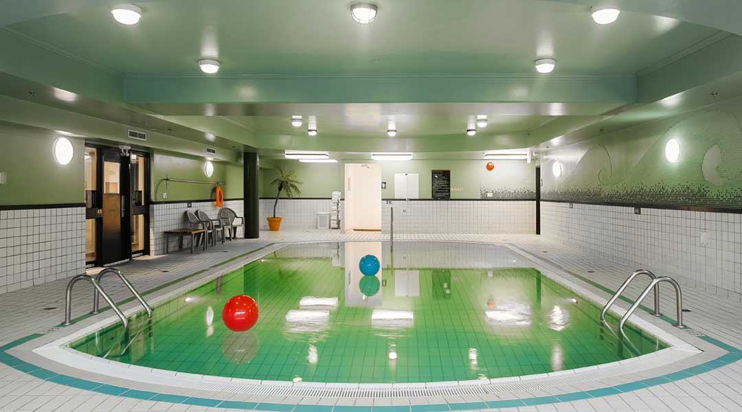 Indoor pool with two inflatable balls floating at the Sandman Hotel in Victoria BC