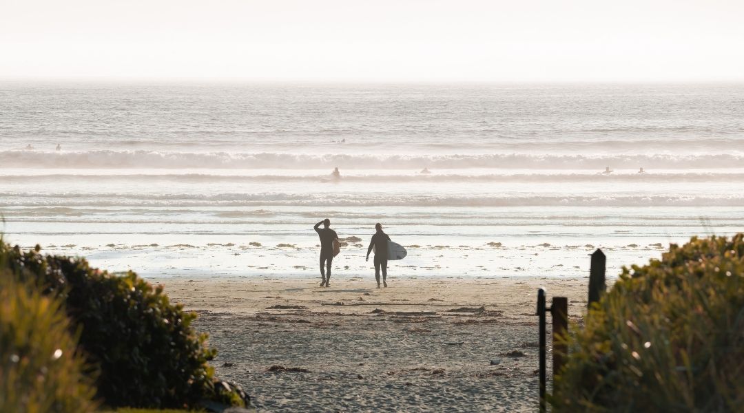 Two people surfing at Long Beach Lodge Resort in Tofino Two people surfing at Long Beach Lodge Resort in Tofino